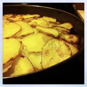 Sliced potatoes with spinach, olives and tomatoes